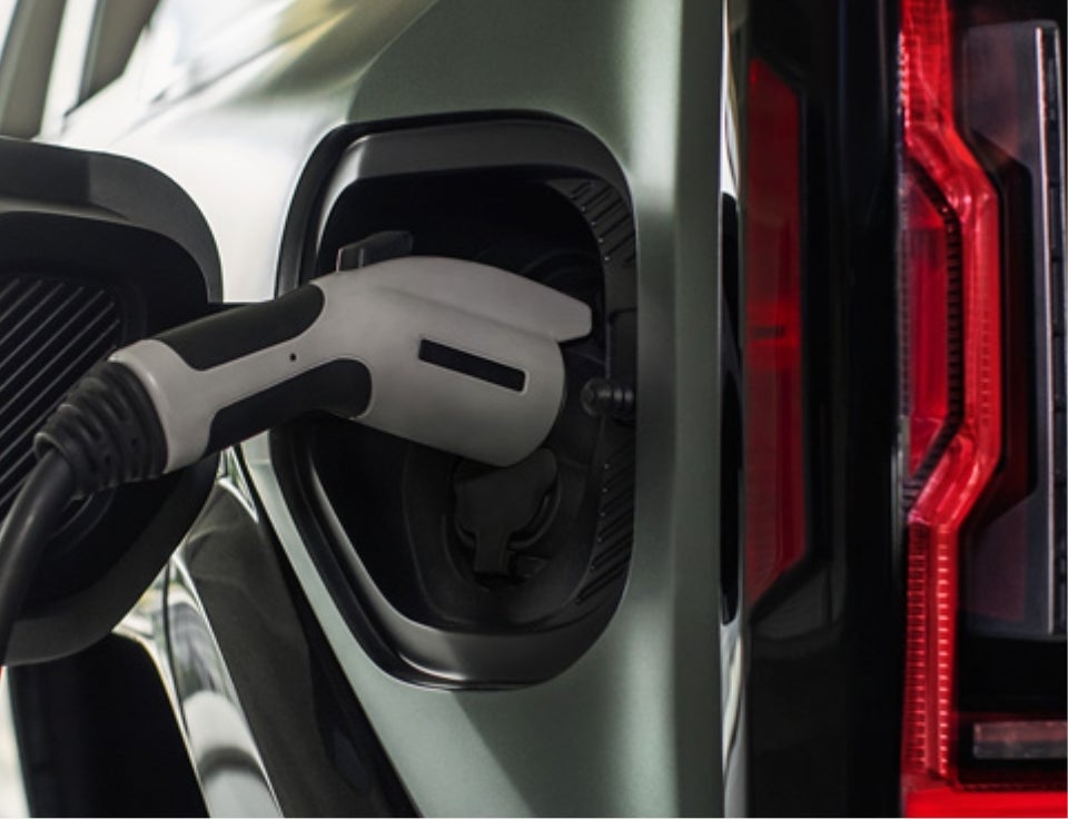 Close up of charging port with charger plugged in on a GMC Hummer EV SUV - Sun GMC in Wantagh NY